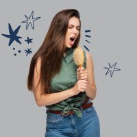 donna che canta con spazzola in mano
