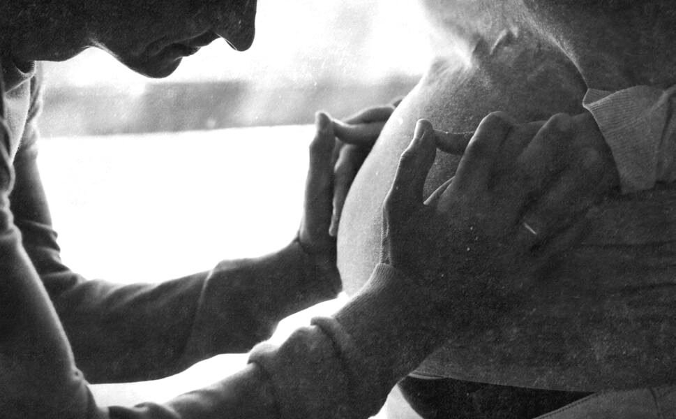 Hombre acariciando a una mujer embarazada